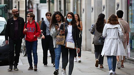 Some companies insist that customers and employees still wear masks.-_119254401_gettyshopperslondon.jpg